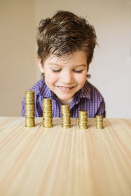 Boy looking at coins on a table